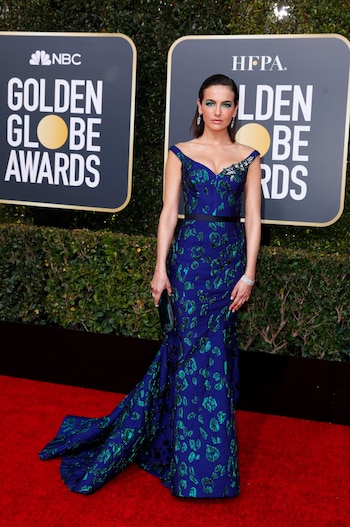 Camilla Belle al cuerpo, escote bardot, corte en la cintura en color azul y turquesa. Su maquillaje acompañaba con las mismas tonalidades que su vestido. ¿Sus joyas? Un brazalete de brillantes, aros gota y clutch de chiffón