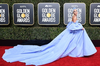 Lady Gaga nominada como mejor actriz, se lució en la red carpet de los Golden Globes con un voluptuoso e imponente vestido celeste. Con mangas acampanadas y escote strapless, acompañó los metros de cola del vestido con su cabello celeste