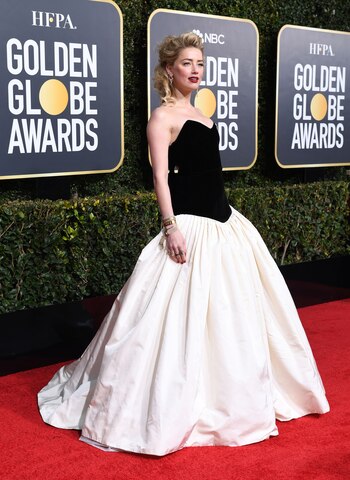 Amber Heard lució un vestido encorsetado. La parte superior en chiffón y una falda vaporosa. Completó el look con anillos y pulseras doradas