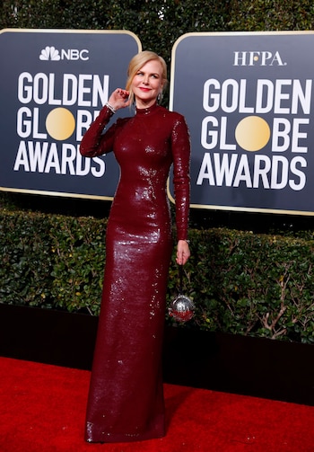 Paillettes y cuello cisne en color borravino. Nicole Kidman completó su look de red carpet con un clutch rígido en forma circular