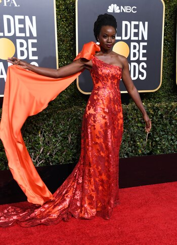 Danai Gurira. Lució un diseño en color naranja, de un solo hombro y paillettes. Sin accesorios ni tampoco maquillaje llamativo