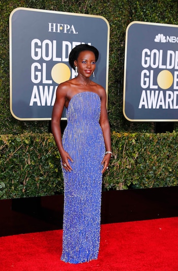 Lupita Nyong’o, al estilo charleston. Con un diseño strapless en azul marino completó su look con dos anillos, una esclava de brillantes y aros cascada