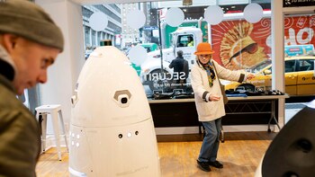Visitantes interactúan con los robots de seguridad Knightscope (Karsten Moran/The New York Times)