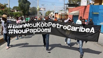 Manifestantes sostienen una bandera con