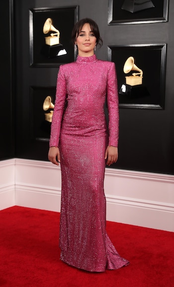 Camila Cabello inauguró la red carpet de los Grammy con un vestido sirena en color fucsia de mangas largas y cuello polera. Lo completó con aros joya en forma de hoja con piedras preciosas