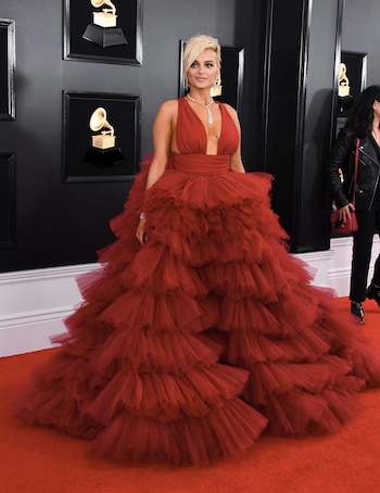 Bebe Rexha apostó a un vestido en rojo pasión vaporoso de tul en cascada. Completó el look con joyas plateadas, un brazalete, un collar y aros colgantes