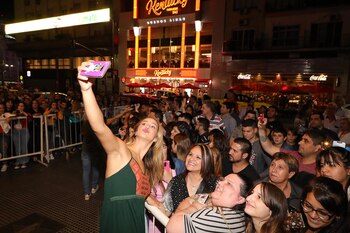 Con buena predisposición, los artistas toman los celulares de los espectadores y sacan las selfies