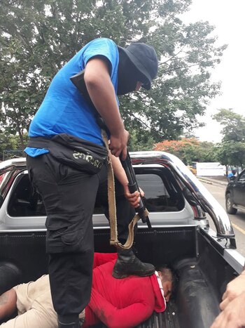 Un paramilitar encapuchado apunta con