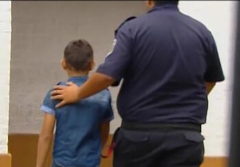 Un policía acompaña al menor,