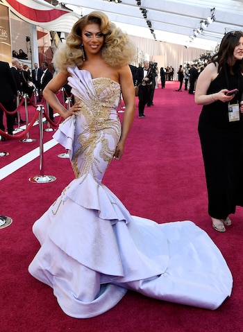 La drag queen Shangela con un vestido sirena en lila y detalles dorados. Un look extravagante pero con mucha personalidad