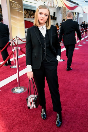 Elsie Fisher by Thom Browne. La actriz centennial de “Eight Grade” eligió un look masculino. Un traje de tres piezas, saco, chaleco y pantalón. Lo completó con booties acharoladas y cartera cuadrada. ¿Los detalles fashionistas? La hebilla en el pelo y el chocker en la camisa