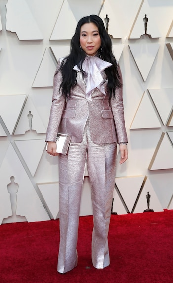 Awkwafina también eligió un look masculino con traje metalizado en plateado. Sumó a su outfit un foulard de organza
