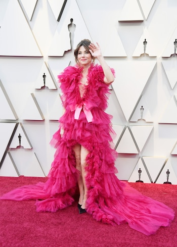 Linda Cardellini enfundada en un vestido escote V de tul en fucsia y loafers negras. Completó su beauty look con un peinado semi recogido
