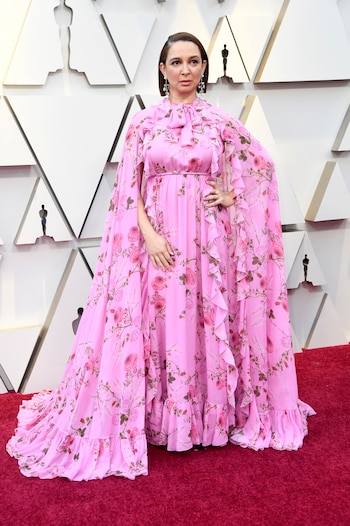 La actriz Maya Rudolph eligió un vestido rosa estampado de rosas con volados y lazo en el cuello. Completó el look con aros colgante y anillos