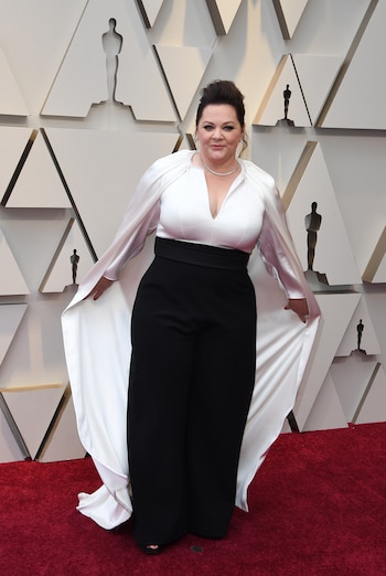 Melissa McCarthy eligió para los Oscars una monoprenda en color blanco y negro que desde el top caía una capa en seda. Completó el look con gargantilla plateada y cabello recogido