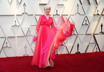 La actriz británica Helen Mirren lució un vestido fucsia con diferentes tonos y mucho tul, con mangas largas con transparencias y un clutch rígido