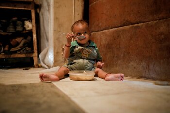 Yeibe Medina, el hijo de un año de María Guitia, se sienta en el suelo alimentándose en su casa cerca de San Francisco de Yare, Venezuela, el 18 de febrero de 2019.