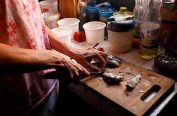 Yaneidi Guzmán prepara unas sardinas en su cocina. Guzmán ha perdido un tercio de su peso en los últimos tres años debido a que el colapso económico de Venezuela hizo que la comida fuera inaccesible y ahora espera que la oposición tenga éxito. En urgente necesidad de ayuda exterior.