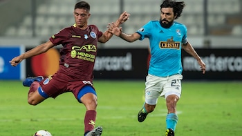 Ezequiel Bullaude de Godoy Cruz cuida la pelota ante la marca de Jorge Cazulo de Sporting Cristal (AFP)