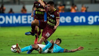 Ezequiel Bullaude de Godoy Cruz recibe una falta de Christofer Gonzales de Sporting Cristal (AFP)