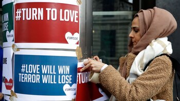 Un manifestante cuelga pancartas del