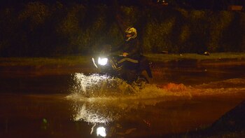 Un motociclista atraviesa el agua