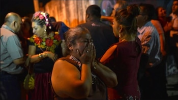 Familiares de las víctimas observan,