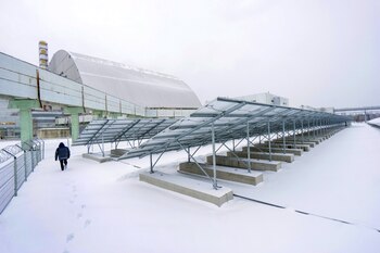 Un trabajador camina a través del parque solar en Chernobyl, Ucrania. Fotógrafo: Vincent Mundy / Bloomberg