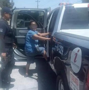 Una mujer (centro) es llevada