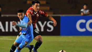 Fernando Gaibor, de Independiente, compite por la pelota con futbolista del Binacional peruano Andy Polar durante el encuentro de vuelta de la Copa Sudamericana en el estadio UNSA en Arequipa (Foto: AFP)