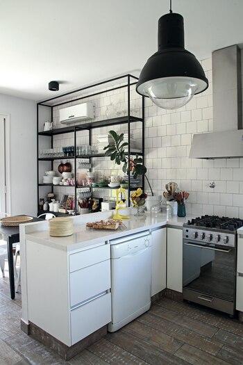 Estantería de hierro a modo de vajillero y azulejos blancos con pastina negra para la cocina.