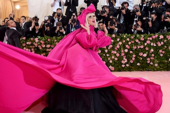 Lady Gaga es una oda al Camp. Así arribó a la alfombra rosa, con un diseño de Brandon Maxwell en fucsia neón, el primero de cuatro looks que lució la ganadora del Oscar. Fue acompañada por cinco bailarines y realizó una performance que dio inicio a la pink carpet