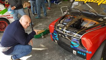 Espert posando con un auto de carreras ploteado con el logo del frente que lidera