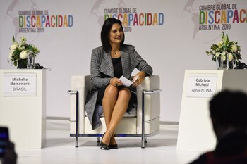 Michelle Bolsonaro optó por un tapado kimono en Príncipe de Gales y un vestido básico negro y stilettos en negro (Franco Fafasuli)