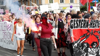 Una manifestante con una bengala