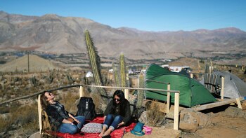 Turistas se sientan en un