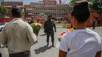 Personas llevan ofrendas florales a