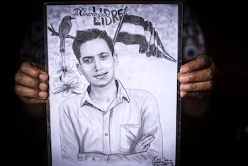 Un familiar sostiene un dibujo en memoria de Cruz Alberto Obregón.