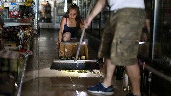 Kaitlin Alexander limpia botellas rotas en el local de licores 1 Stop Market tras el terremoto del 4 de julio (Foto: Reuters/David McNew)