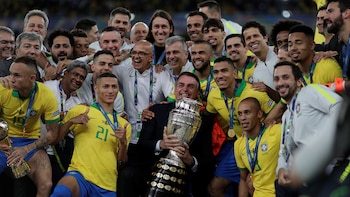 El presidente Jair Bolsonaro, con el trofeo de la Copa América, rodeado por los futbolistas de Brasil (Foto: REUTERS/Ueslei Marcelino)