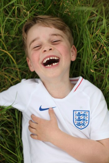 En dos de las imágenes se puede observar al tercero en la línea de sucesión de la corona jugando en los jardines del Palacio de Kensington, vestido con la camiseta blanca de fútbol de Inglaterra
