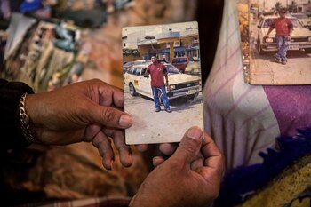 Arias sostiene una foto de su hijo Jimmy, un taxista asesinado en 2011 en Honduras por una pandilla que lo estaba extorsionando