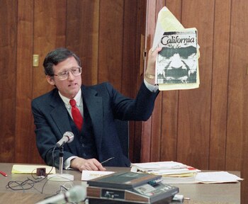 ARCHIVO – En esta fotografía de archivo, del 9 de febrero de 1989, el fiscal federal adjunto de Los Ángeles, Stephen Kay, sostiene una revista que muestra al homicida convicto Charles Manson cuando emitía sus declaraciones finales durante la audiencia de libertad condicional para el procesado en la prisión de San Quintín, en California (AP Photo/ Eric Risberg, archivo)