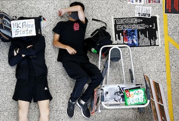 Dos jóvenes manifestantes antigubernamentales duermen en el suelo del aeropuerto de Hong Kong (REUTERS/Thomas Peter)