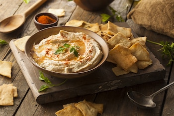 El hummus es una crema de puré de garbanzos de Medio Oriente, hecha con ajo, jugo de limón y tahini. La pasta se ha convertido en un elemento básico de las heladeras de todo el mundo