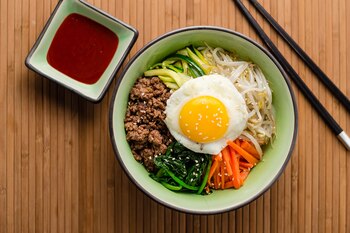 El bibimbap coreano es un colorido y sabroso bowl de arroz cubierto con un huevo frito y servido con verduras calientes