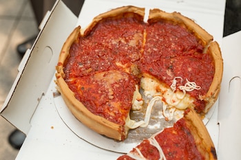 La pizza estilo Chicago se elabora tradicionalmente abierta, como la focaccia, y tiene una base de pan gruesa, honda y crujiente, rellena de queso y salsa de tomate en trozos