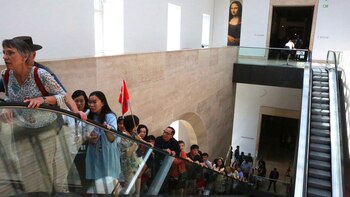 Los visitantes tienen que tomar tres escaleras eléctricas para llegar hasta el hogar temporal de la Mona Lisa (Owen Franken para The New York Times)