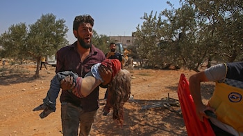 Un sirio carga el cuerpo de una niña en el lugar del bombardeo (Photo by Abdulaziz KETAZ / AFP)