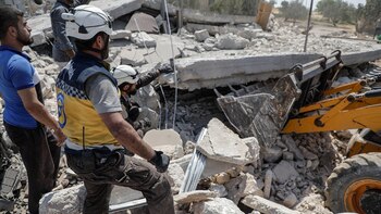 Miembros de los cascos blancos buscan víctimas después del bombardeo del régimen sirio en Deir Sharqi (Photo by Abdullah Hammam / AFP)